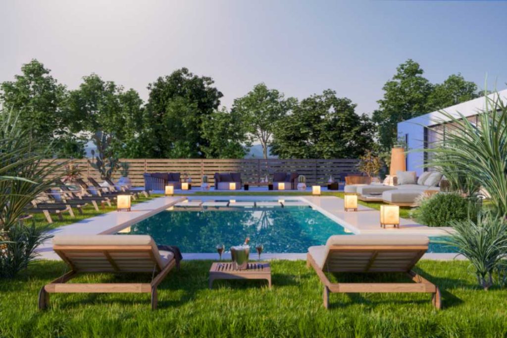 Outdoor pool area with lounge chairs and lanterns surrounds a rectangular pool.