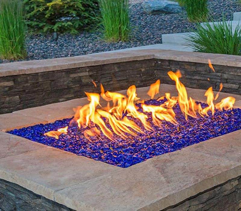 Outdoor stone fire pit installation on a custom paver patio in Denver, CO