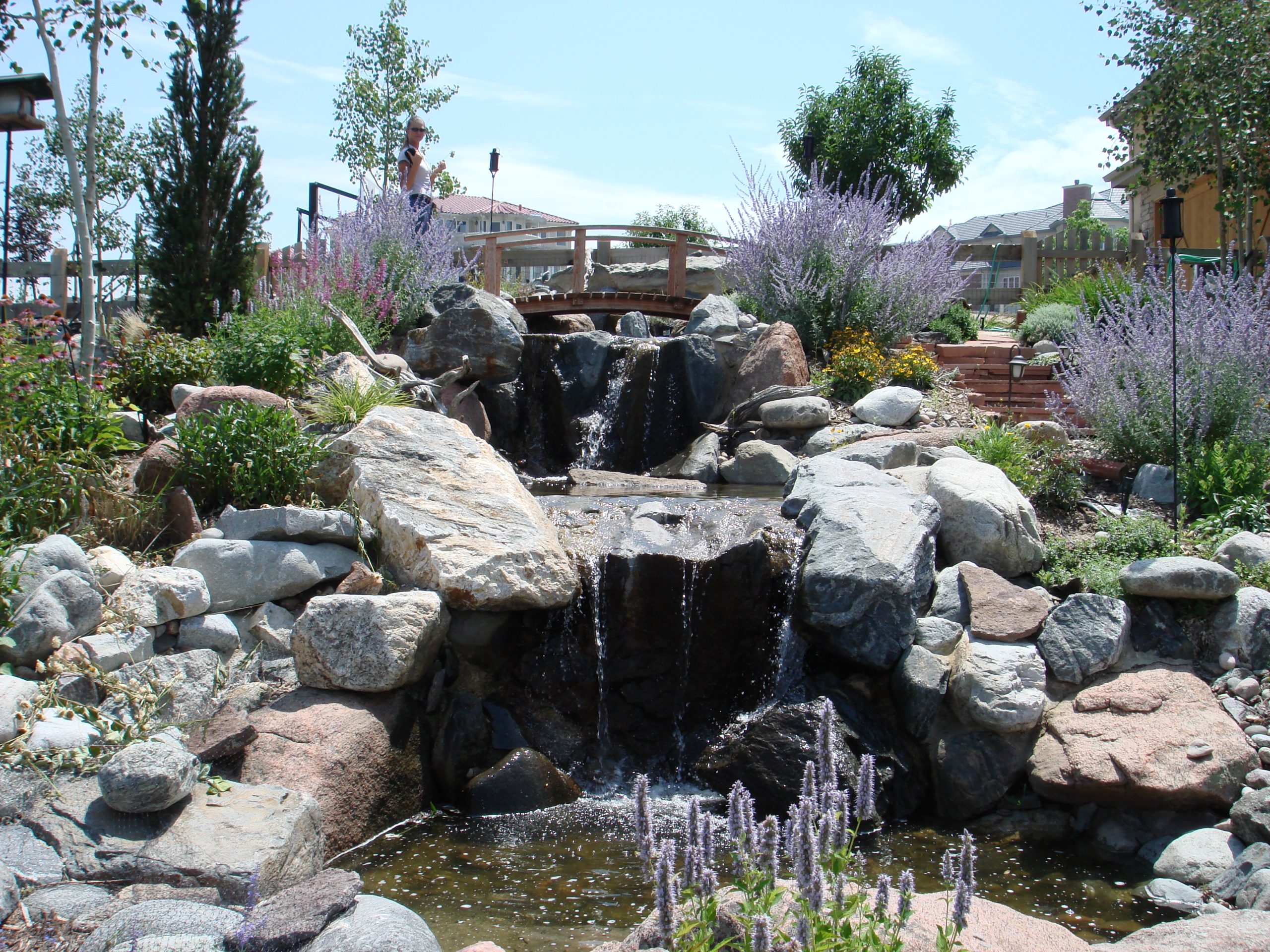 fancy waterfall bridge built by Blue Sky Hardscapes & Irrigation Systems