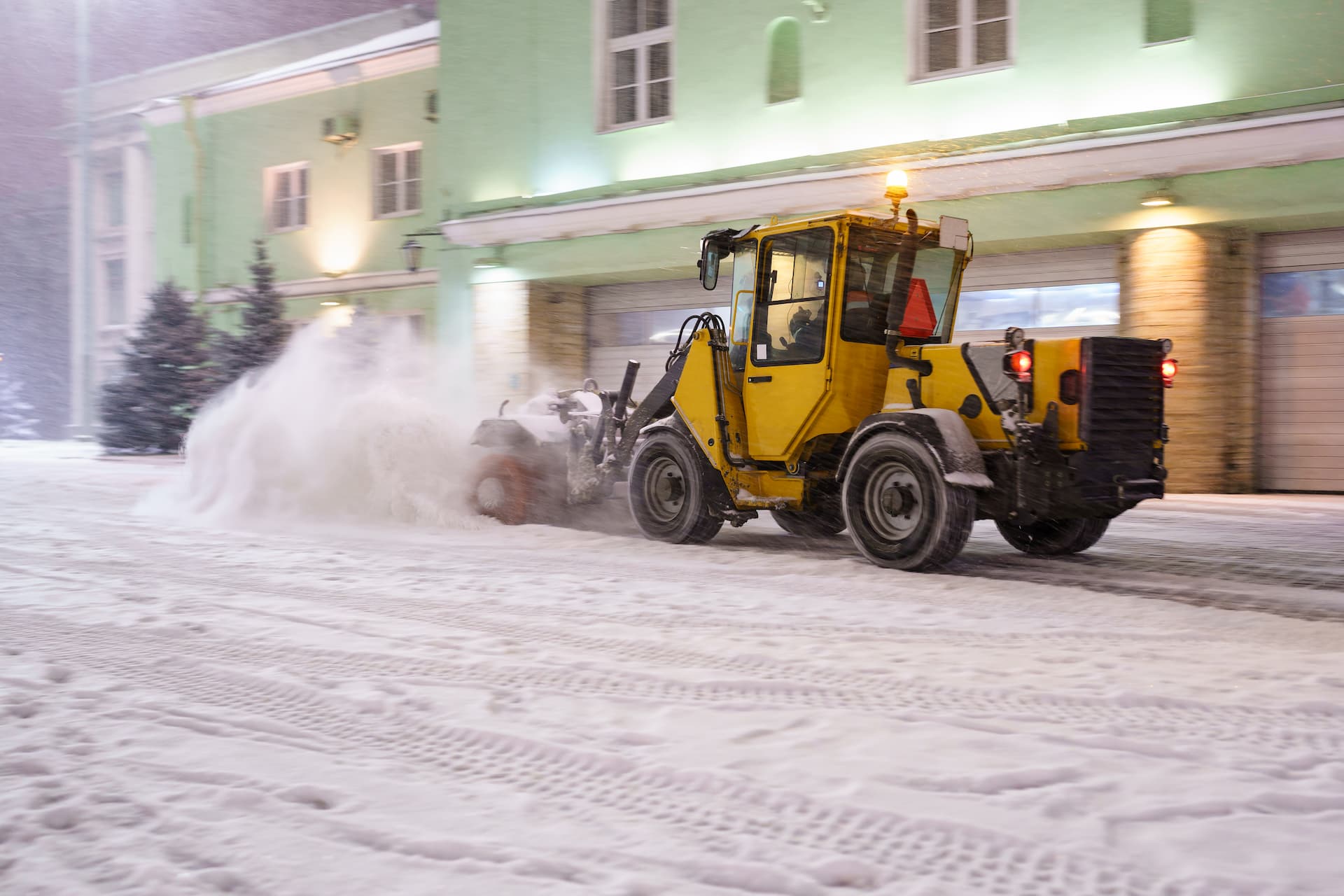 Snow Plowing truck removing snow on a commercial building